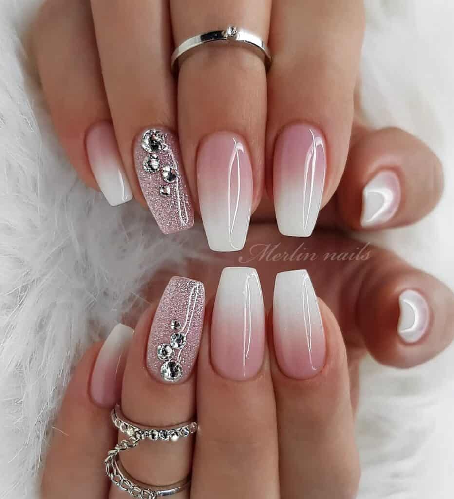 pink and white ombre coffin nails with glitter and crystal accent gems