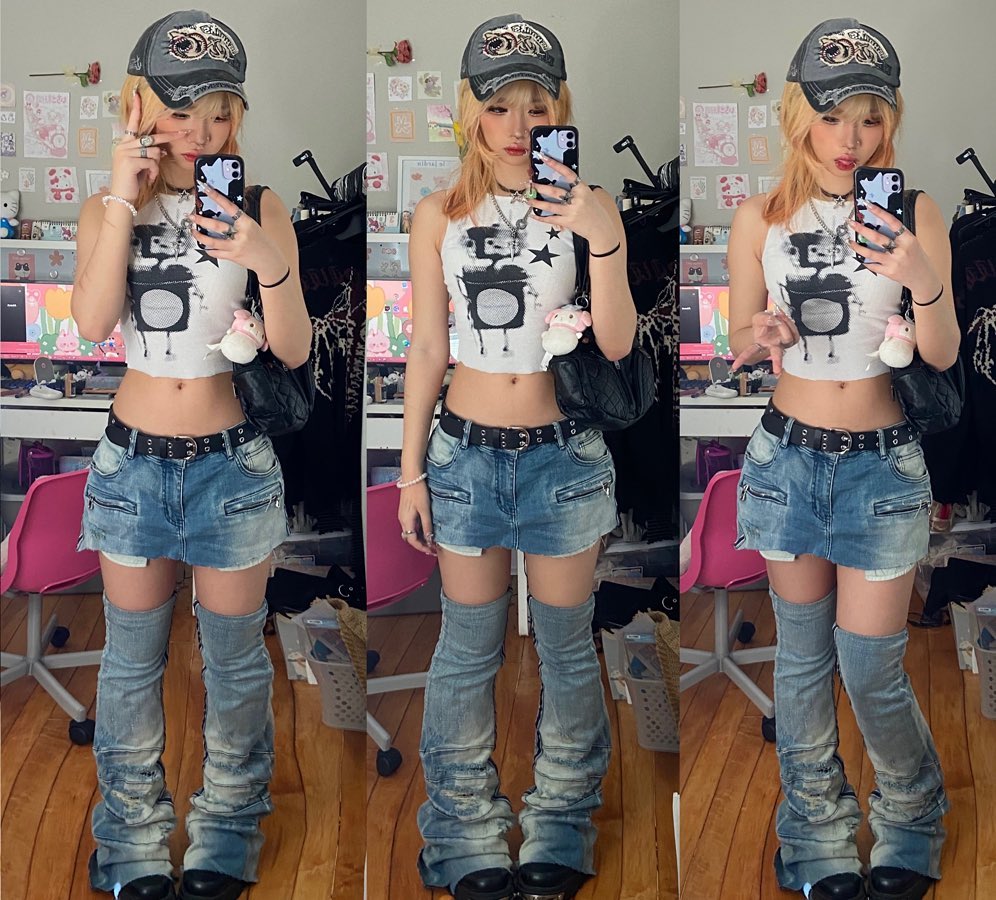 blonde woman wearing a graphic tank top, denim mini skirt, and stacked denim leg warmers