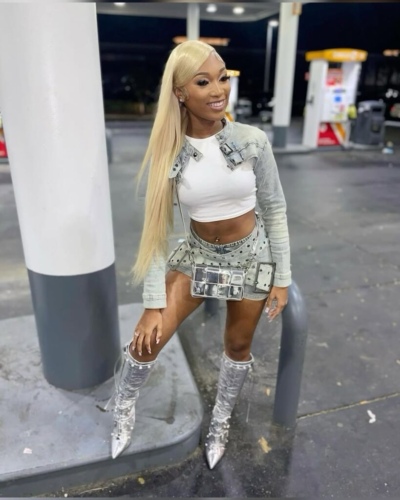 woman in y2k fashion wearing a denim bandage skirt, cropped jacket, and silver boots