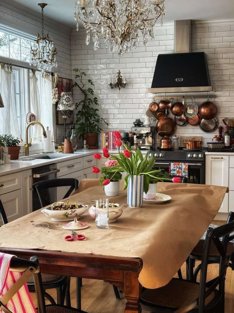 kitchen table covered in brown paper with red tulips and potted plants for spring potting.