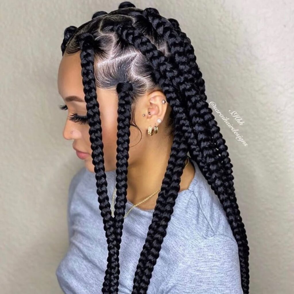 side profile of a woman with thick black box braids and styled baby hairs