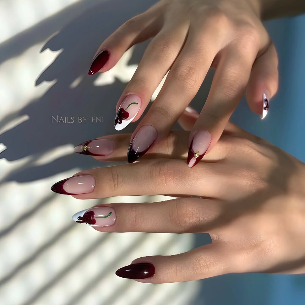 long almond cherry nails with dark red french tips and cherry art accents