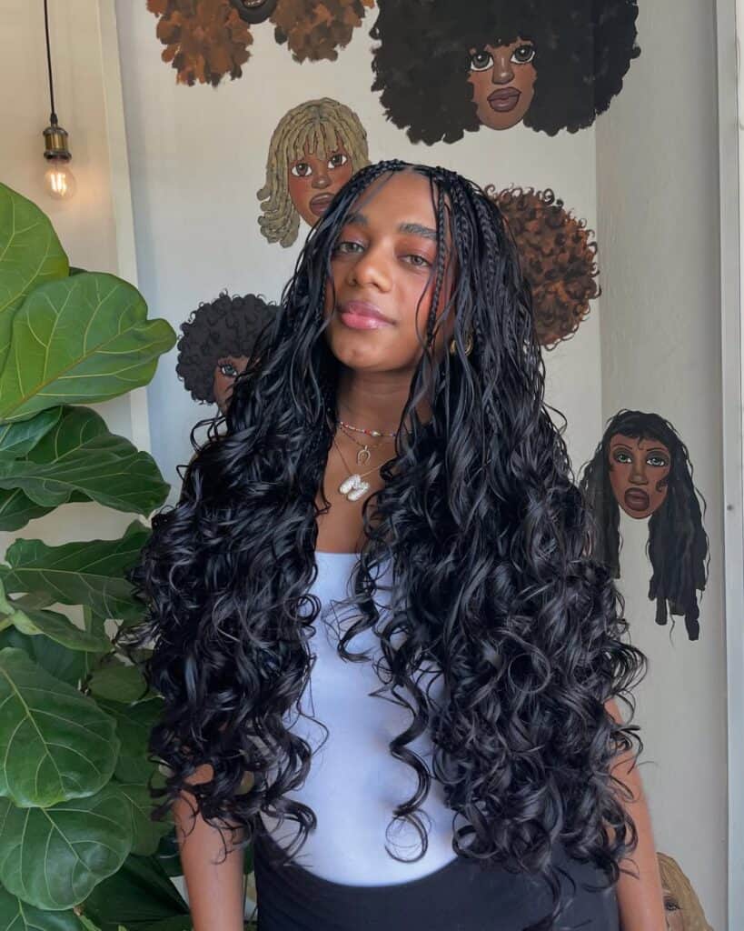 woman with extra long black bohemian braids and loose curls posing in a studio