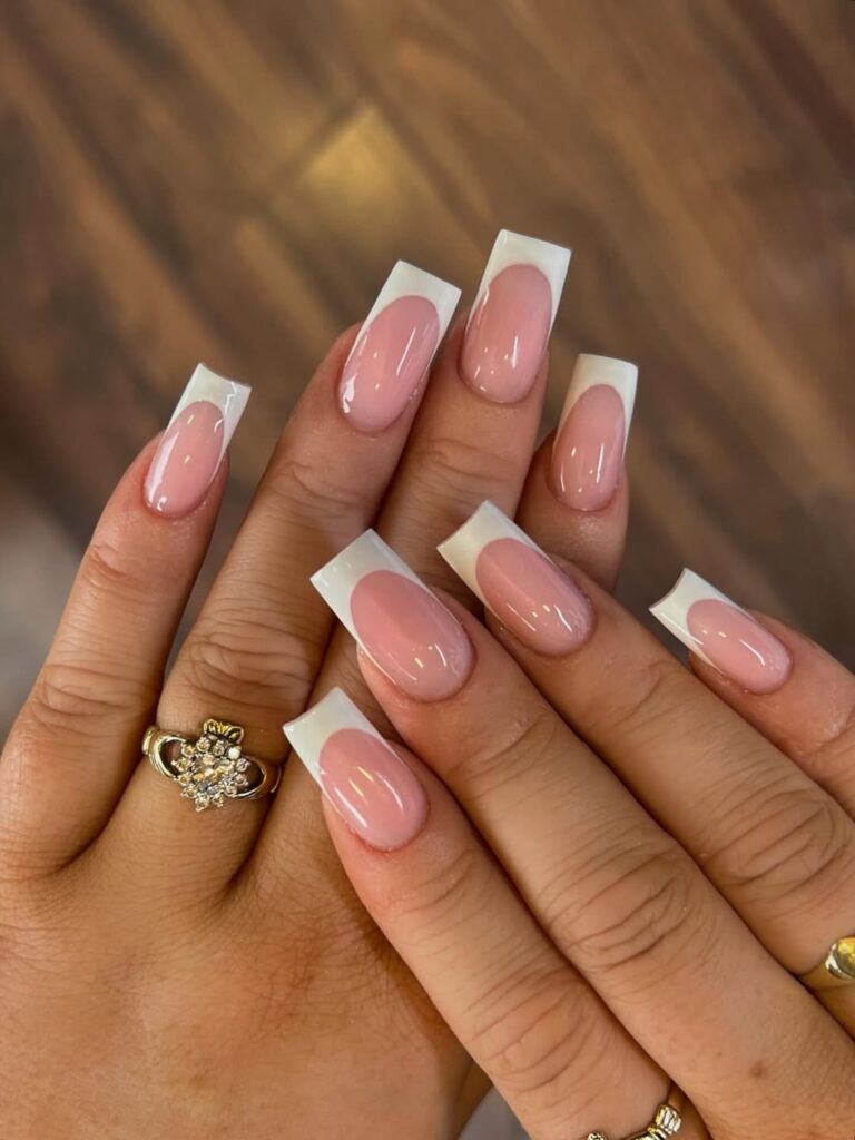 long square white french tip nails with a nude base and gold diamond ring