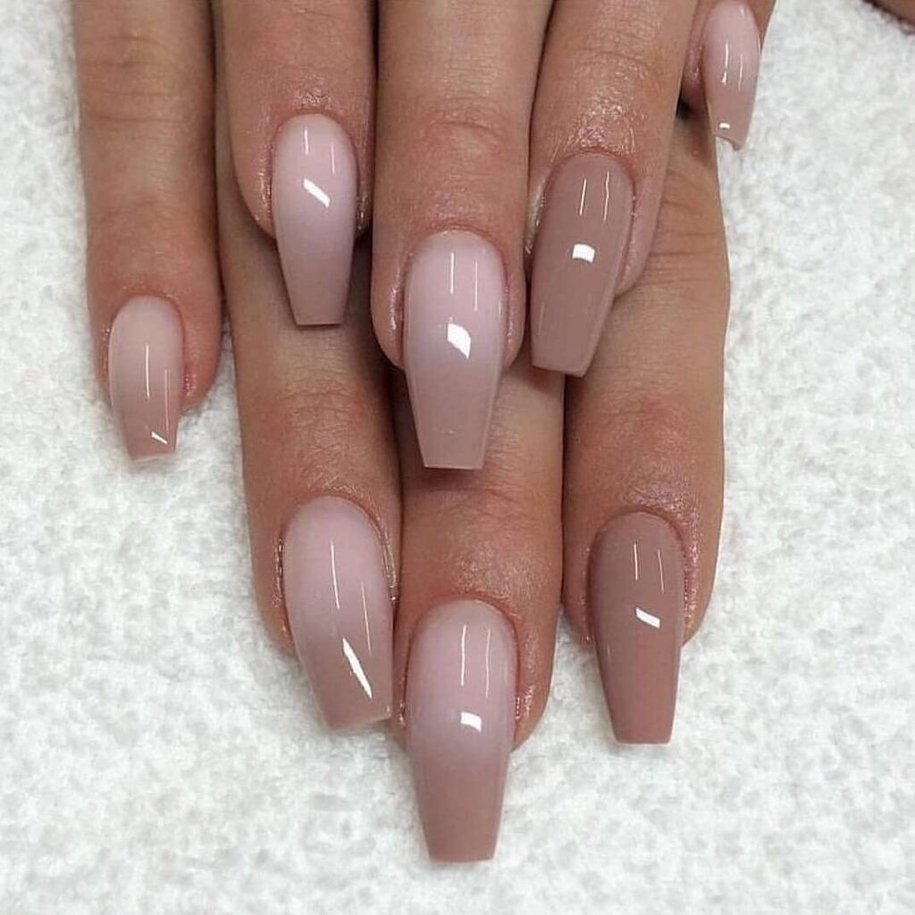 long coffin shaped ombre nails transitioning from nude to soft taupe with glossy finish