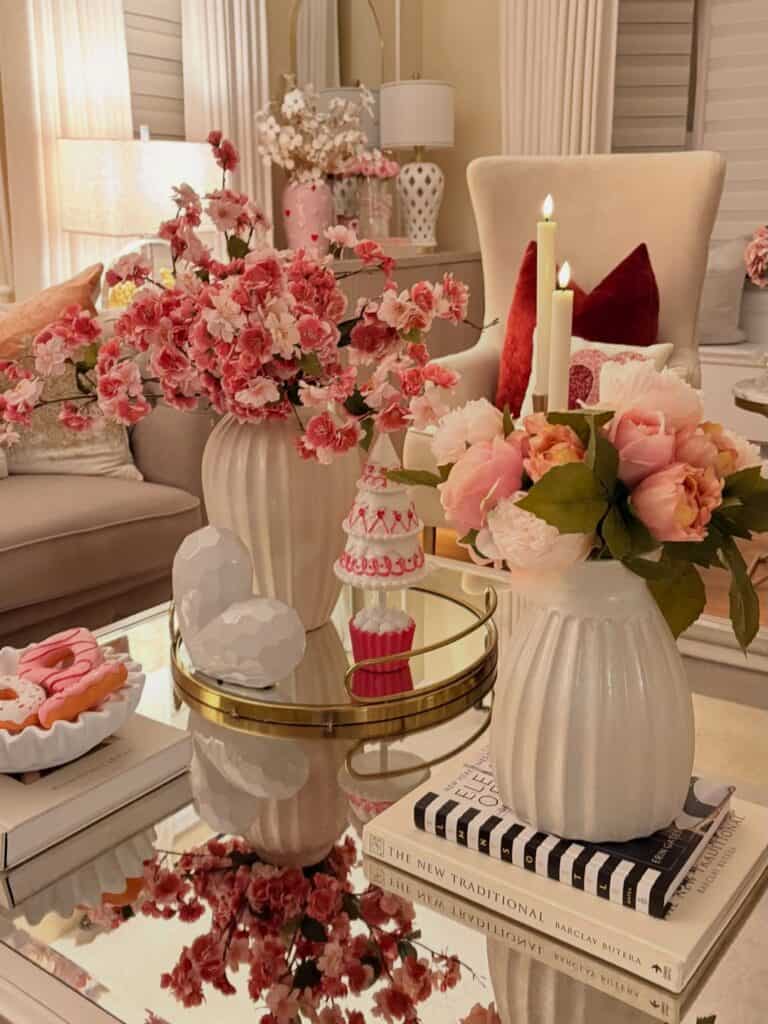 mirrored coffee table styled with pink cherry blossoms, candles, and decorative valentine's day accents.