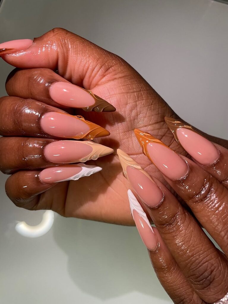 long stiletto nails with brown swirl french tips in various chocolate and caramel shades