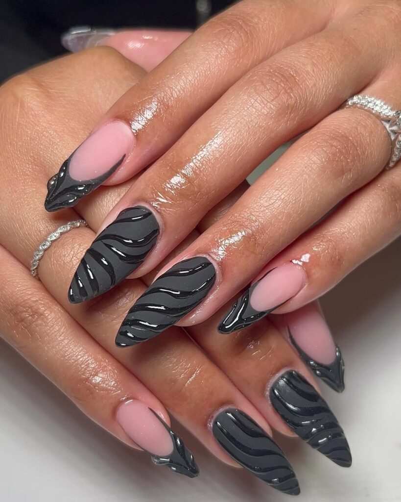 long almond matte black nails with glossy 3d swirl accents and silver rings