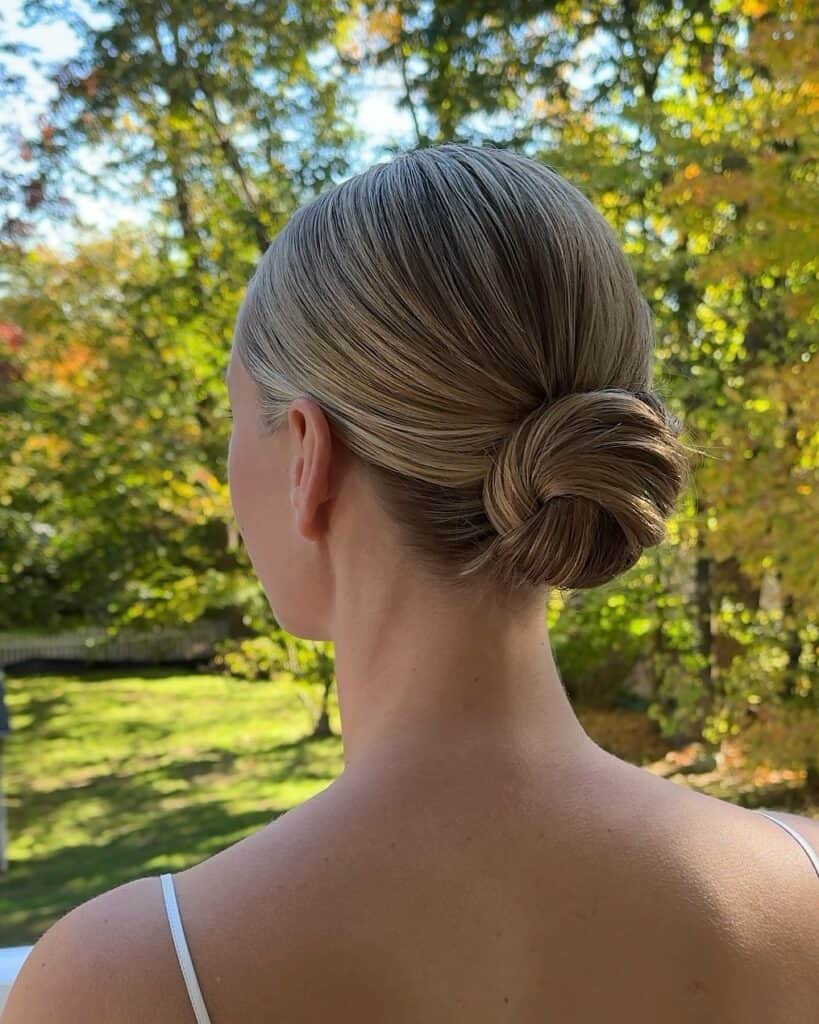 back view of a woman with blonde hair styled in a neat low twisted bun