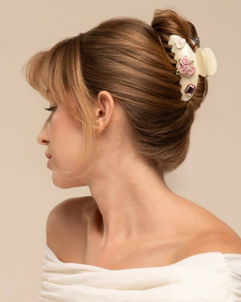 side profile of a woman with hair styled in a bun using a floral claw clip