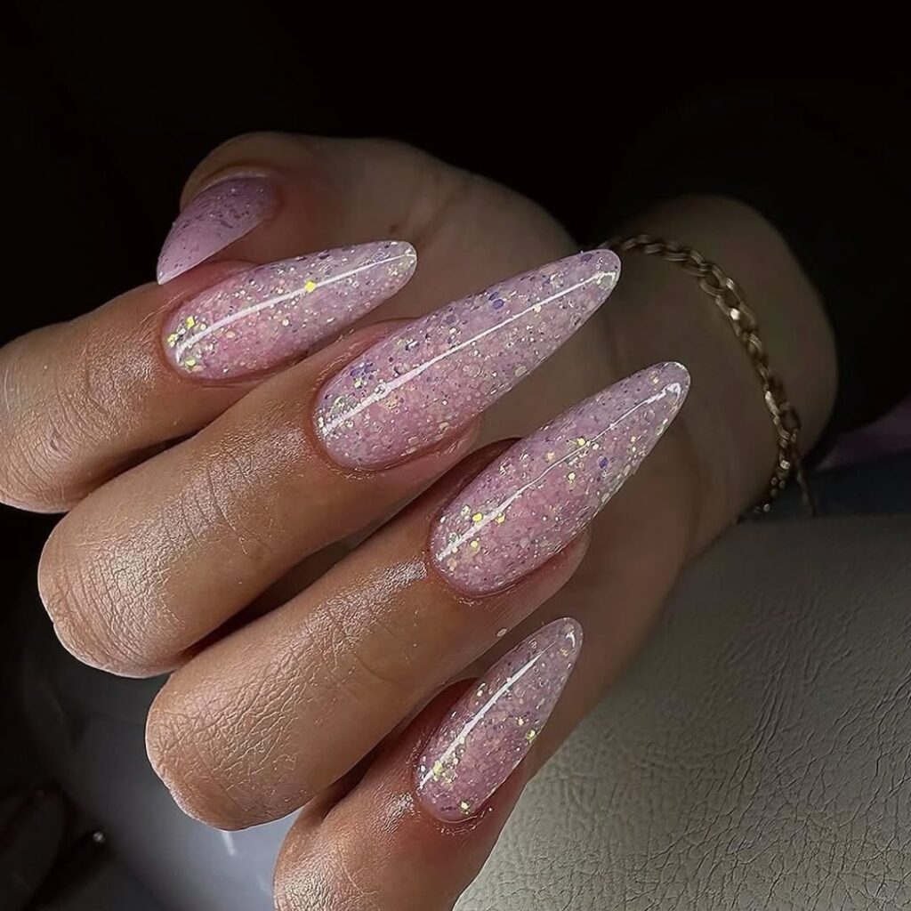 long almond stiletto nails with pink holographic glitter and a glossy top coat