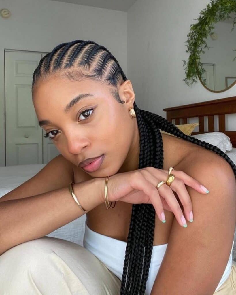 woman with neat stitch braids pulled back into a long low ponytail