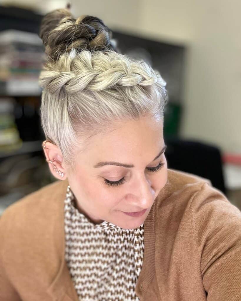 woman with a blonde crown dutch braid styled into a high bun updo