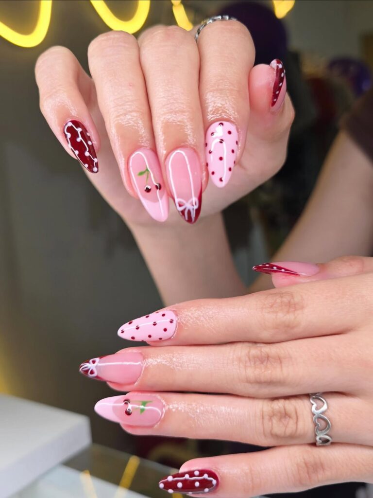 almond pink and burgundy nails with cherry art white bows and red polka dots