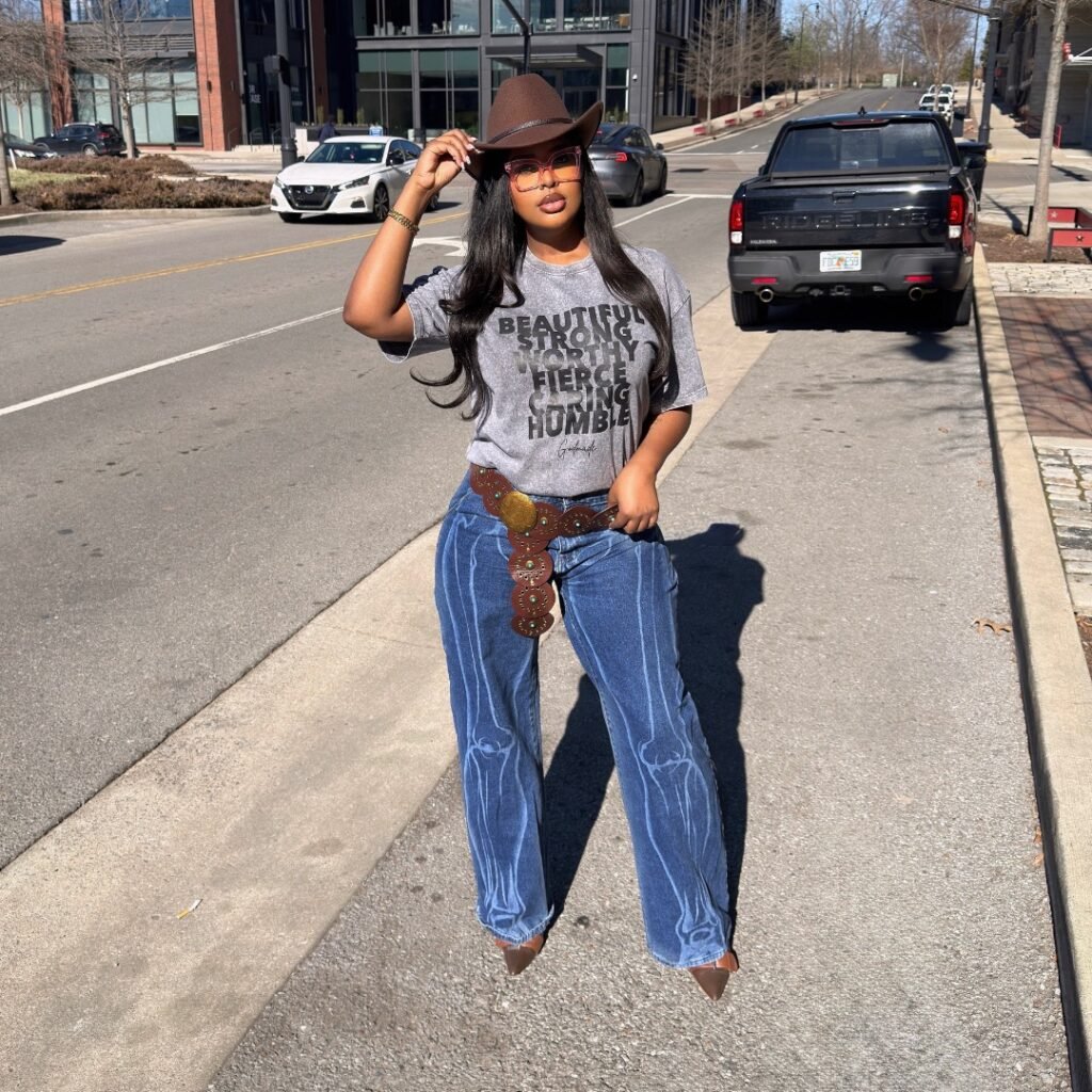 woman wearing brown cowboy hat and blue jeans with skeletal pattern on city street