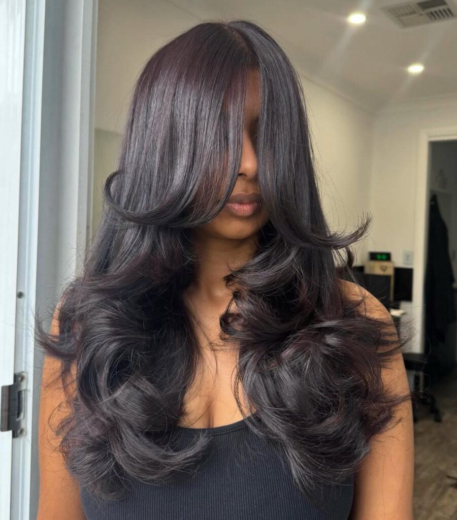 voluminous glossy dark brunette hair with bouncy layers and curled ends