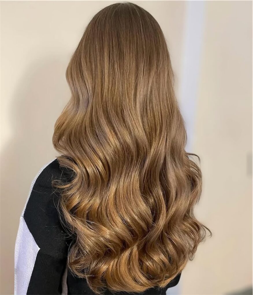back view of long golden light brown hair with soft wavy curls