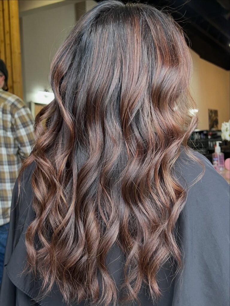 long wavy brunette hair with warm auburn highlights and subtle curls
