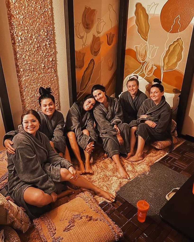 bridesmaids in grey robes posing during a spa party bridal shower.