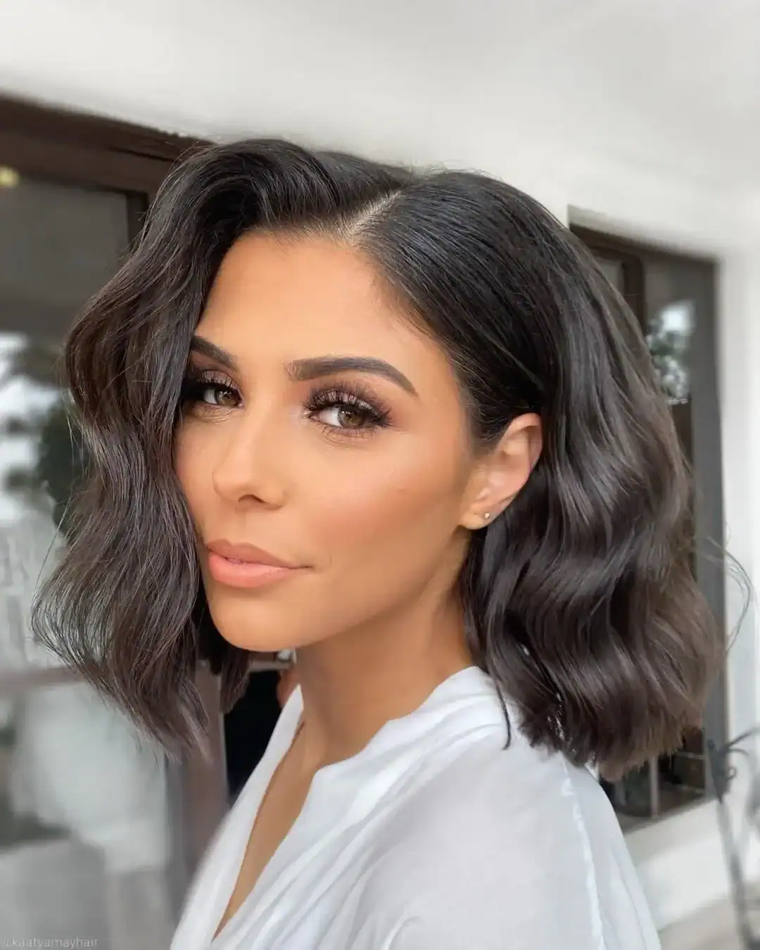 woman with a dark wavy lob hairstyle and elegant soft makeup