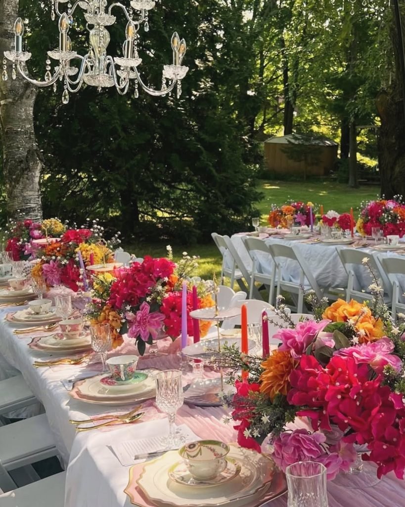 backyard high tea party with crystal chandelier, colorful floral centerpieces, and elegant tea sets