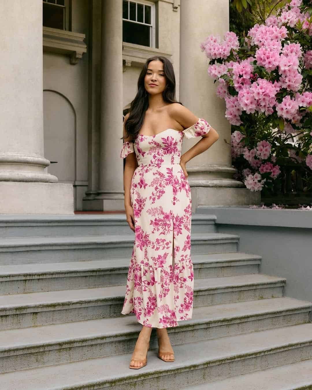 woman in a pink and white floral off the shoulder dress on stone steps