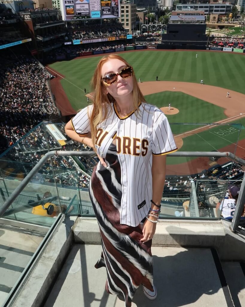 Woman in pinstripe Padres jersey and patterned maxi dress overlooking Petco Park field