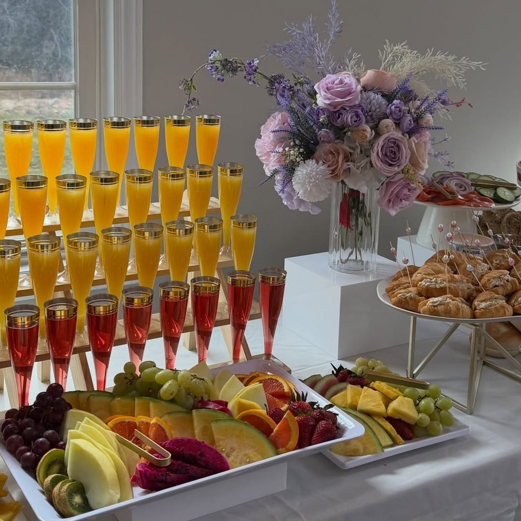 mimosa bar and fruit platters prepared for a bridal shower breakfast.