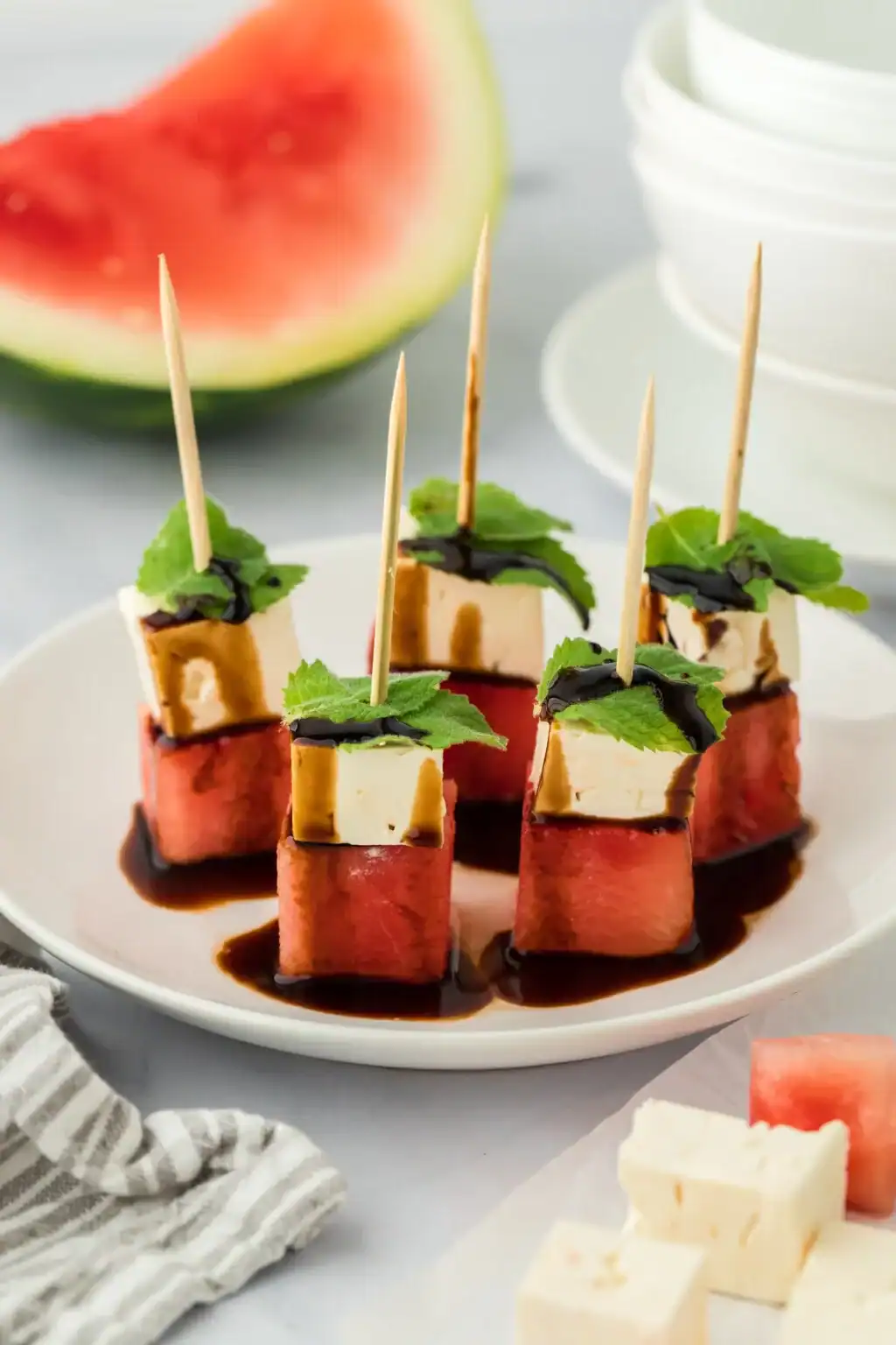 watermelon and feta skewers drizzled with balsamic glaze and topped with mint