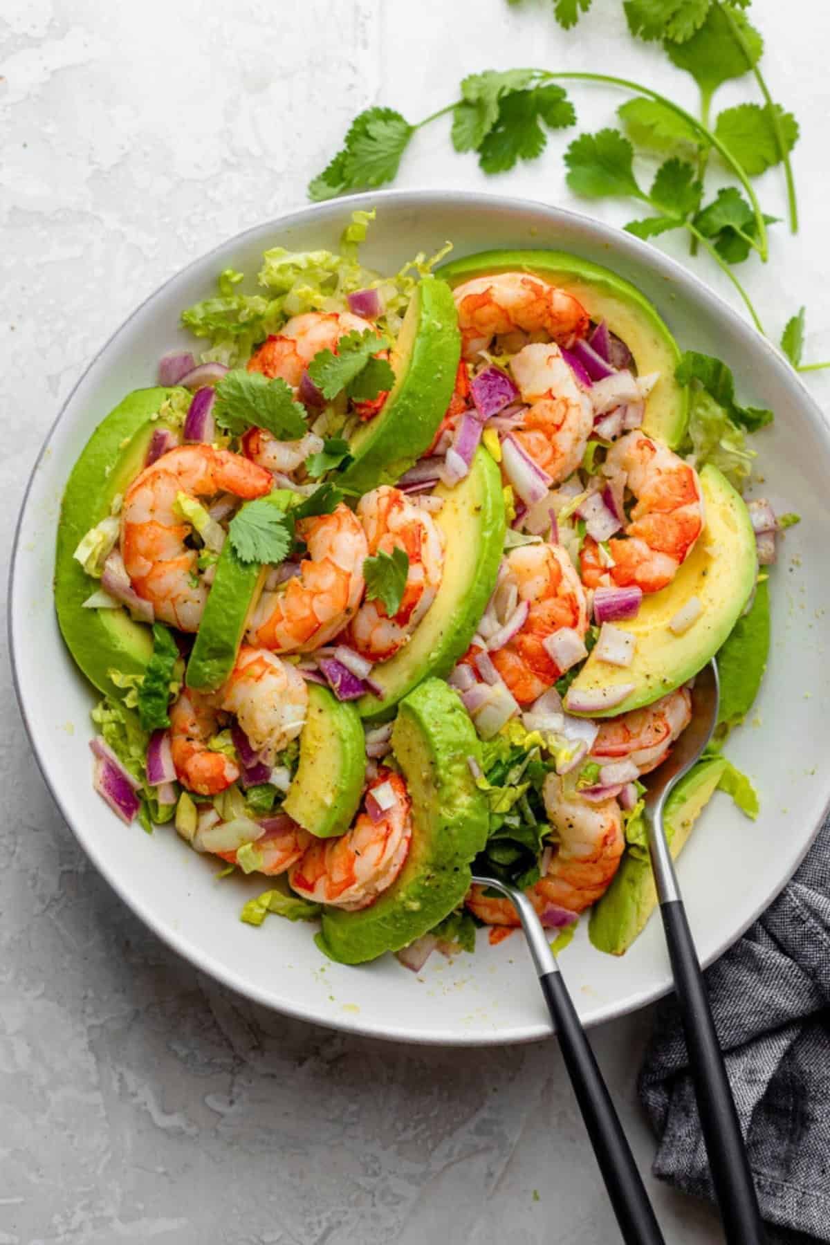 shrimp avocado salad with red onion and fresh cilantro in a large bowl.