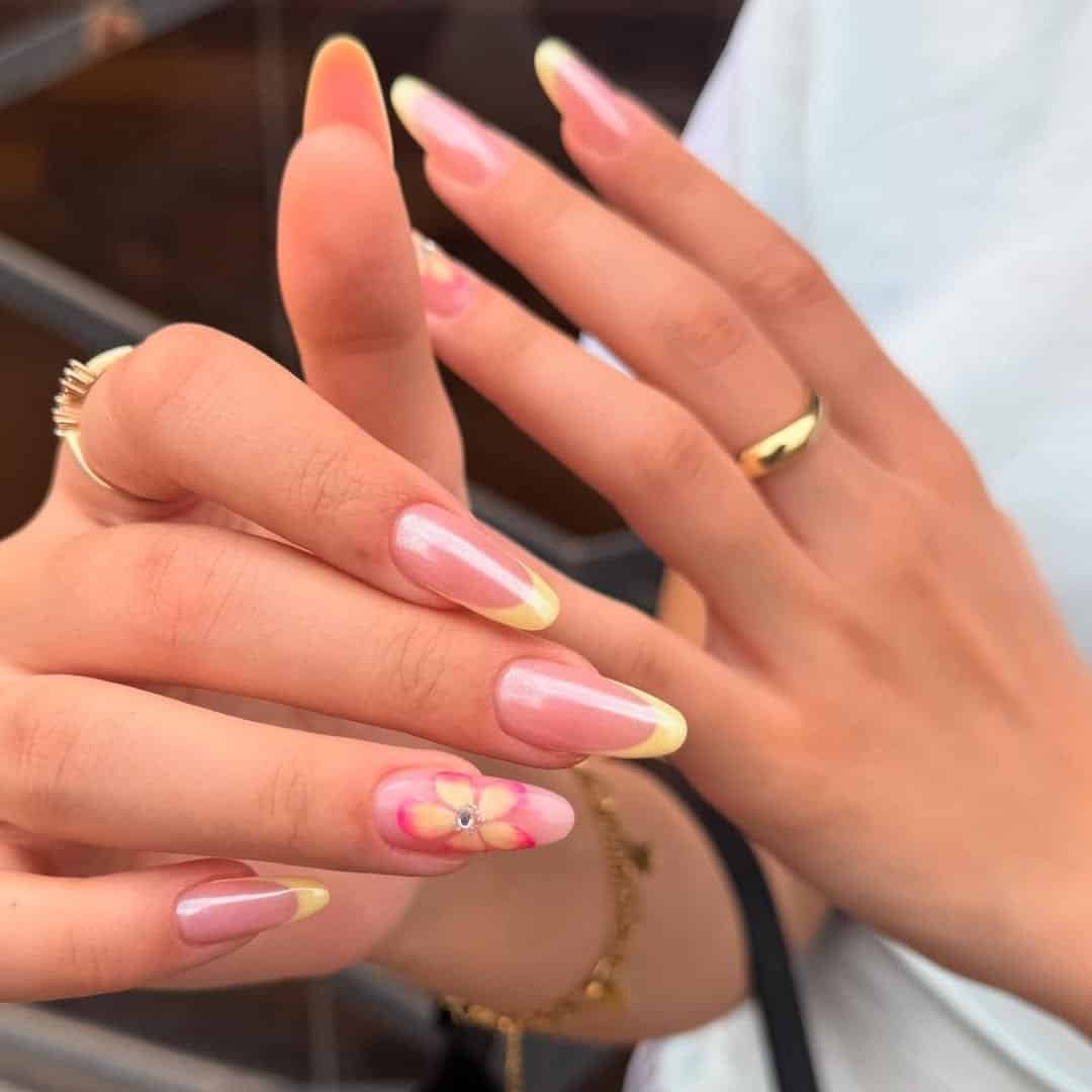 long almond fingernails with yellow french tips and a pink flower design