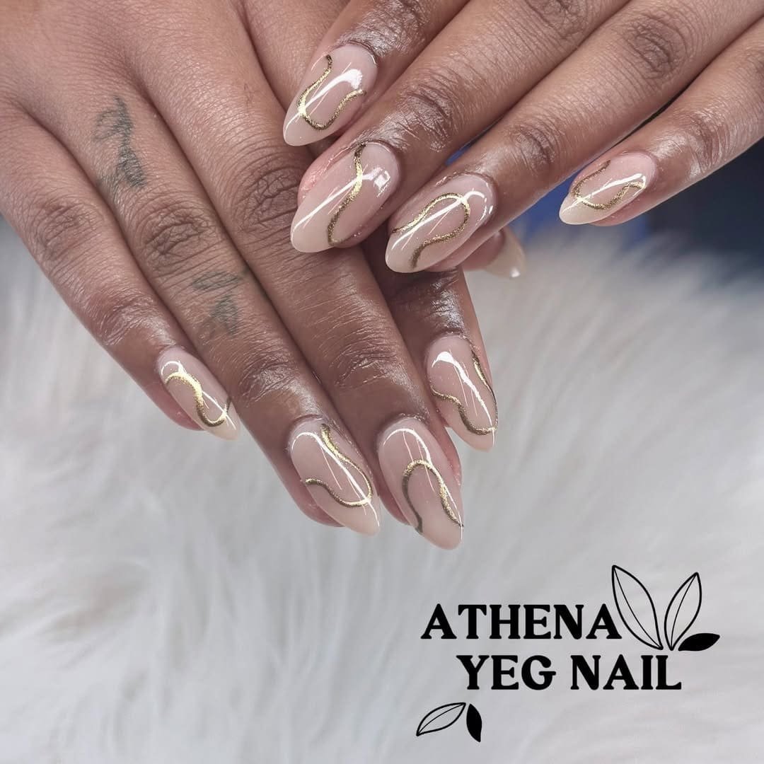 almond beige nude nails with a winding gold glitter design