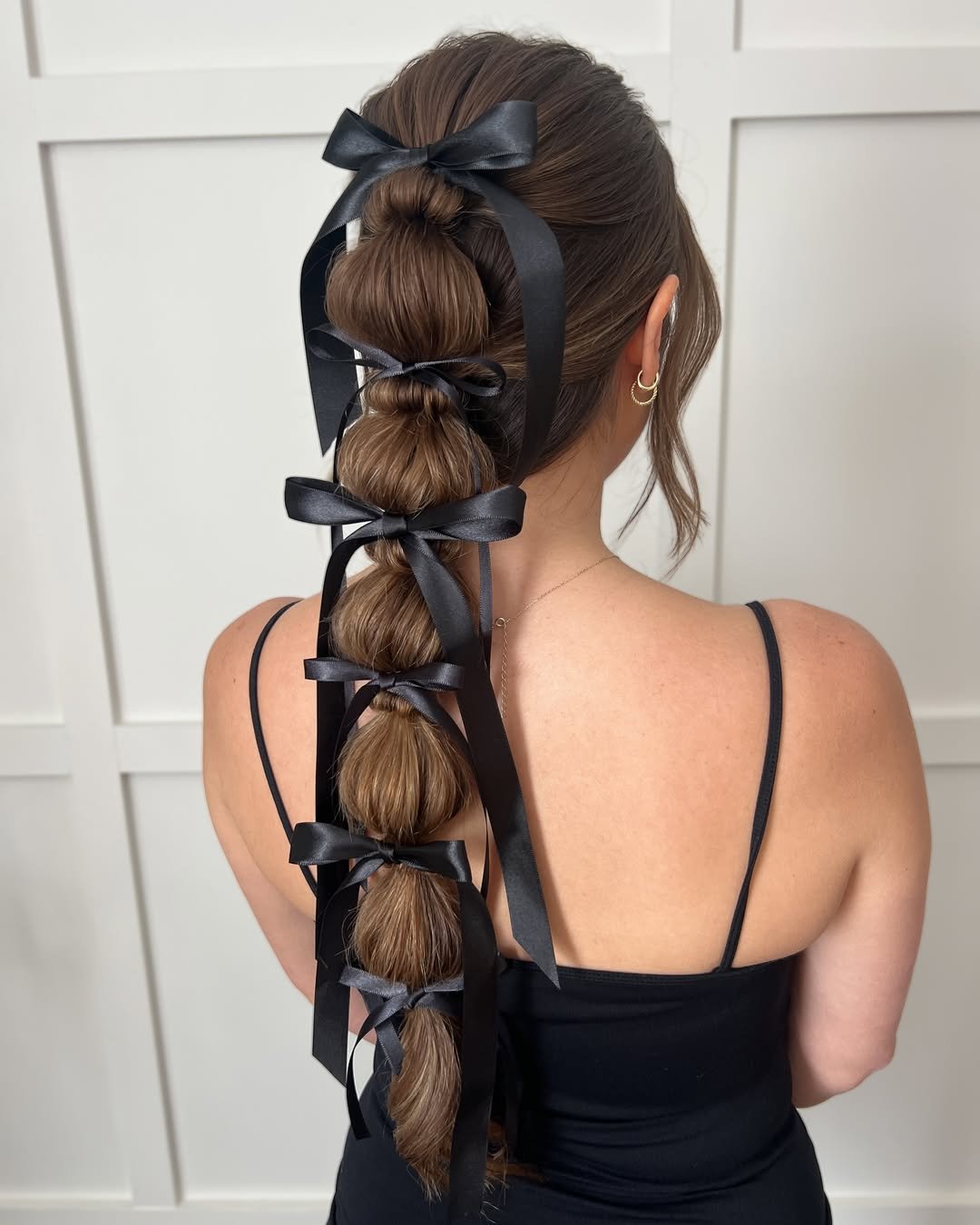 long brunette bubble braid hairstyle accented with multiple delicate black silk bows