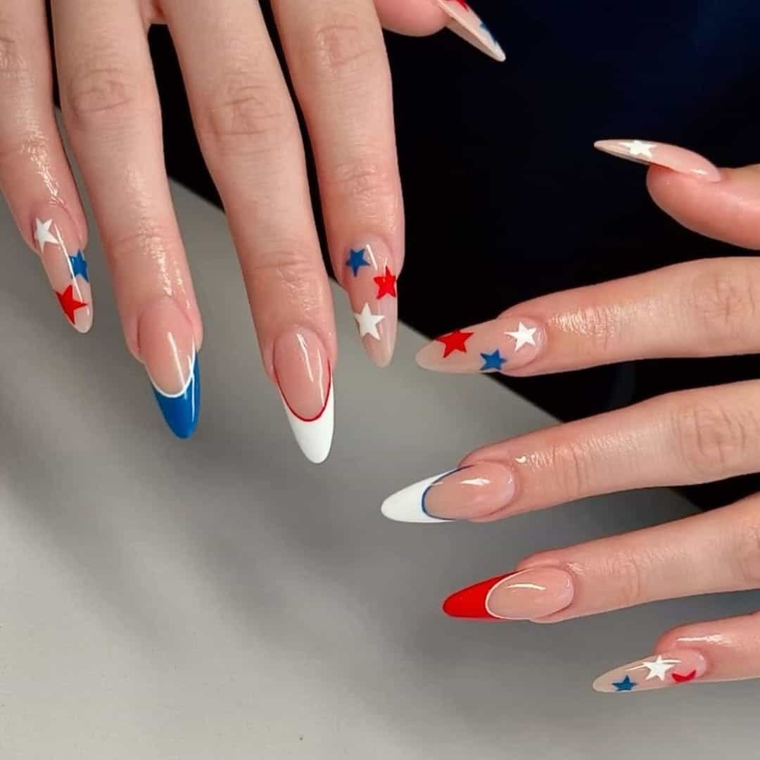 long almond nails featuring red and white french tips and festive stars.