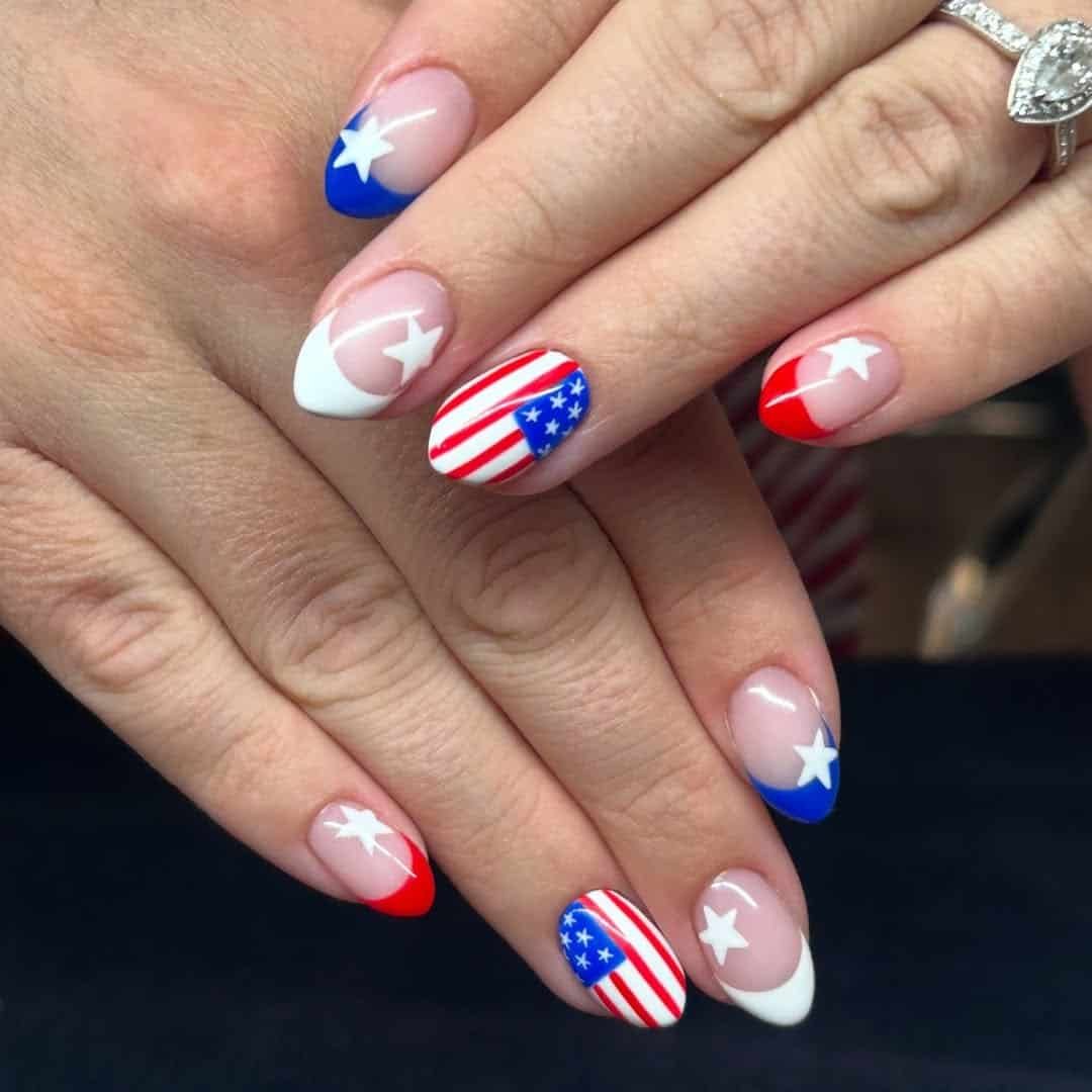 short oval nails with american flag patterns and white stars on blue tips.