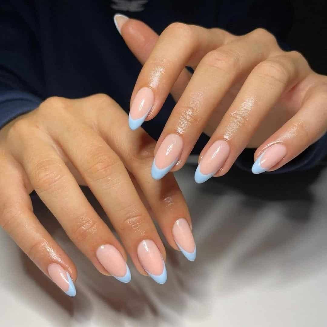 long oval manicure with light blue french tips on a neutral base color