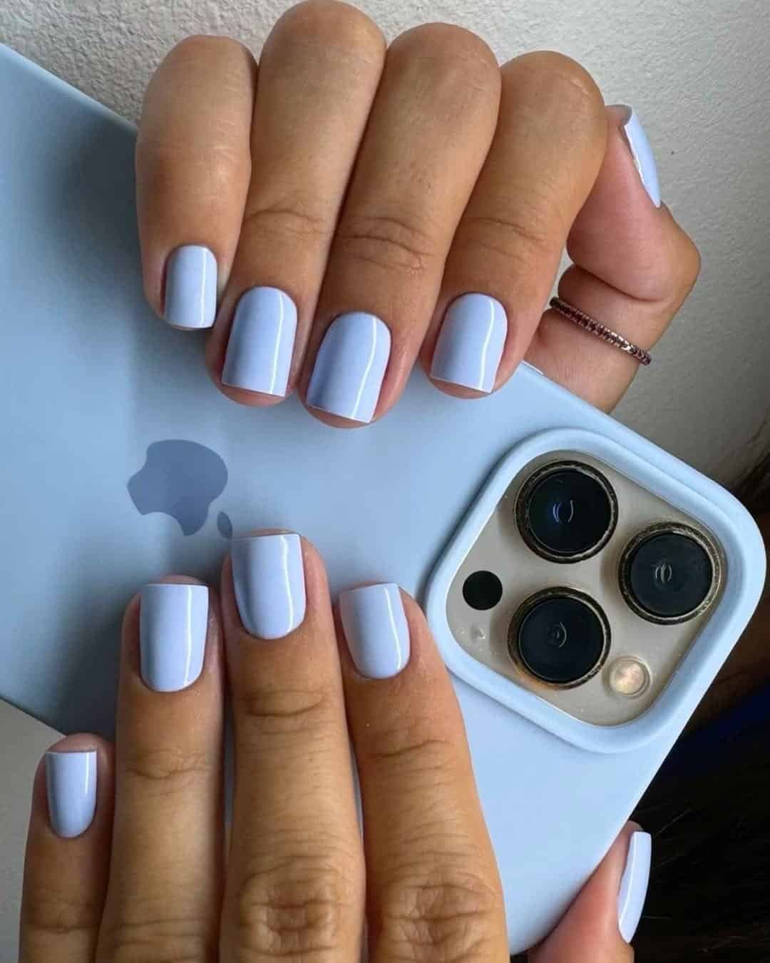 short square nails with a pastel baby blue polish holding a matching blue phone