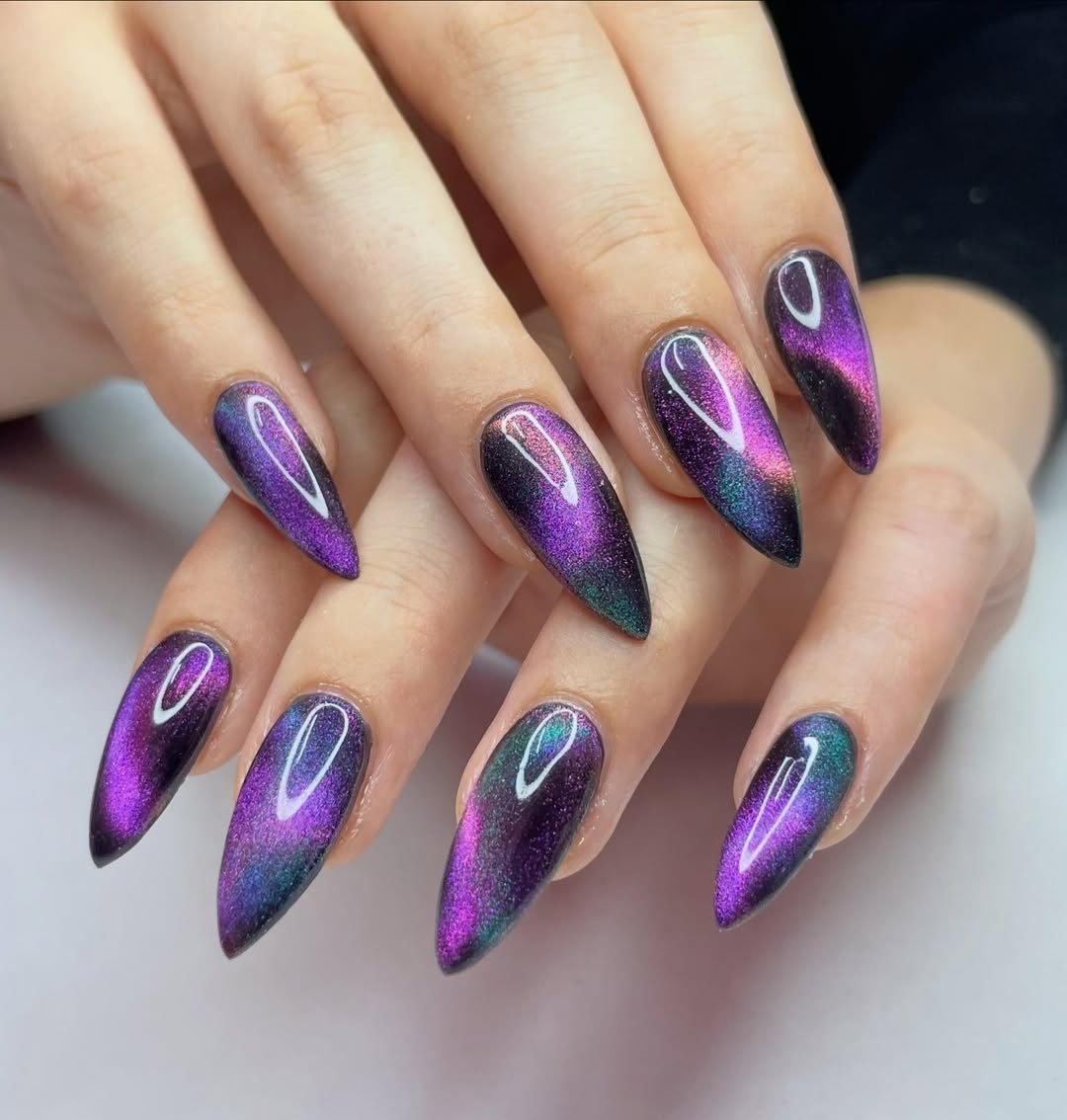 long stiletto galaxy cat eye nails with purple and blue magnetic shimmer and holographic glitter.