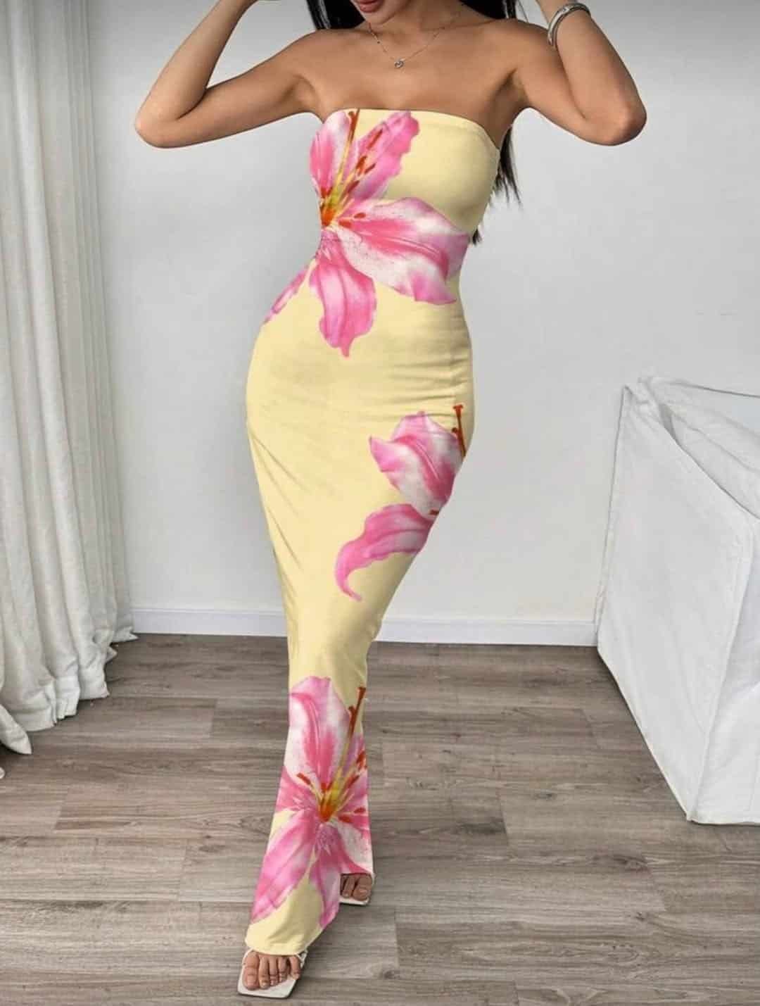 woman posing in a strapless yellow maxi dress with large pink floral prints