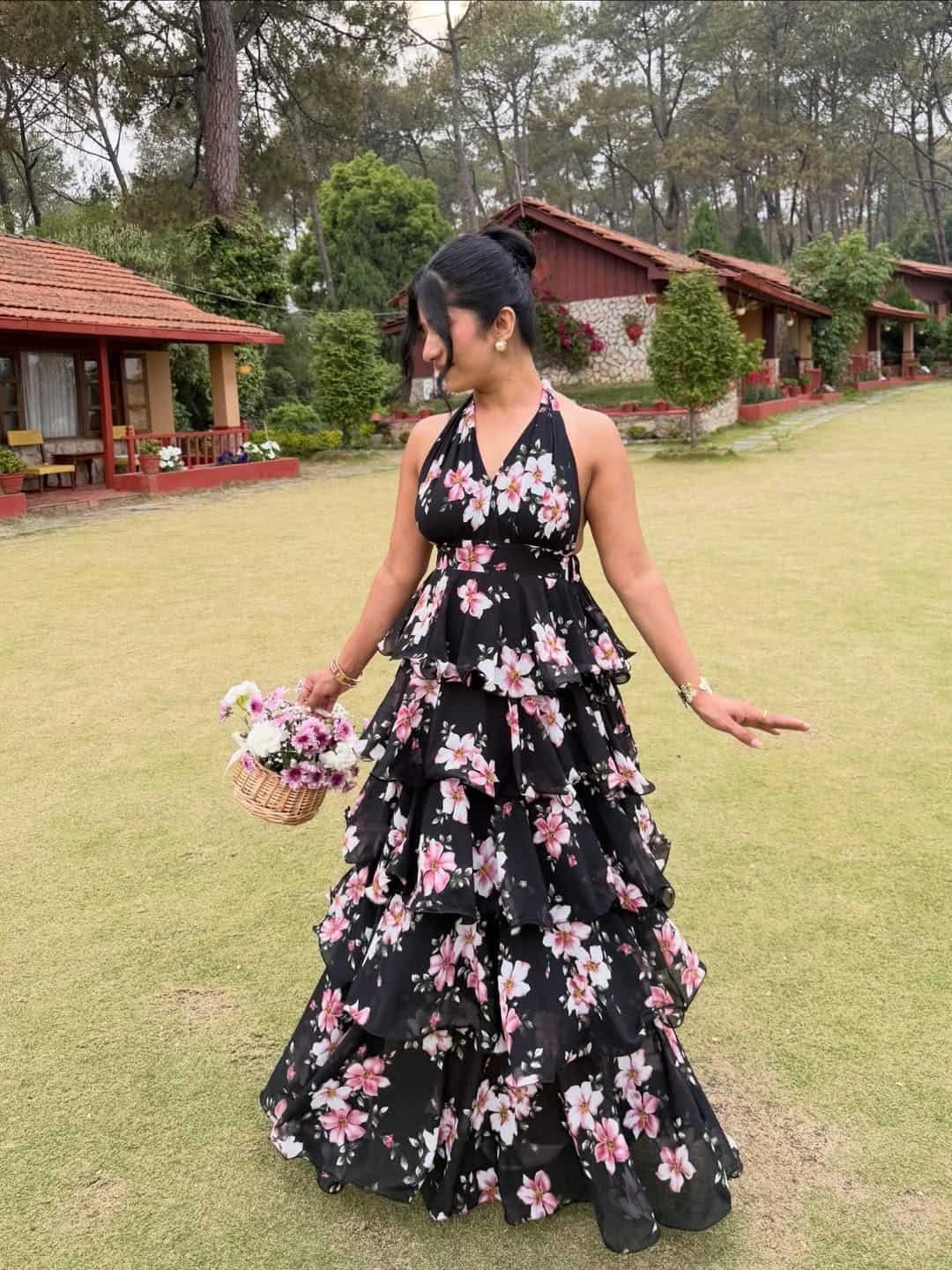 woman in a black halter neck tiered maxi dress with pink floral prints outdoors