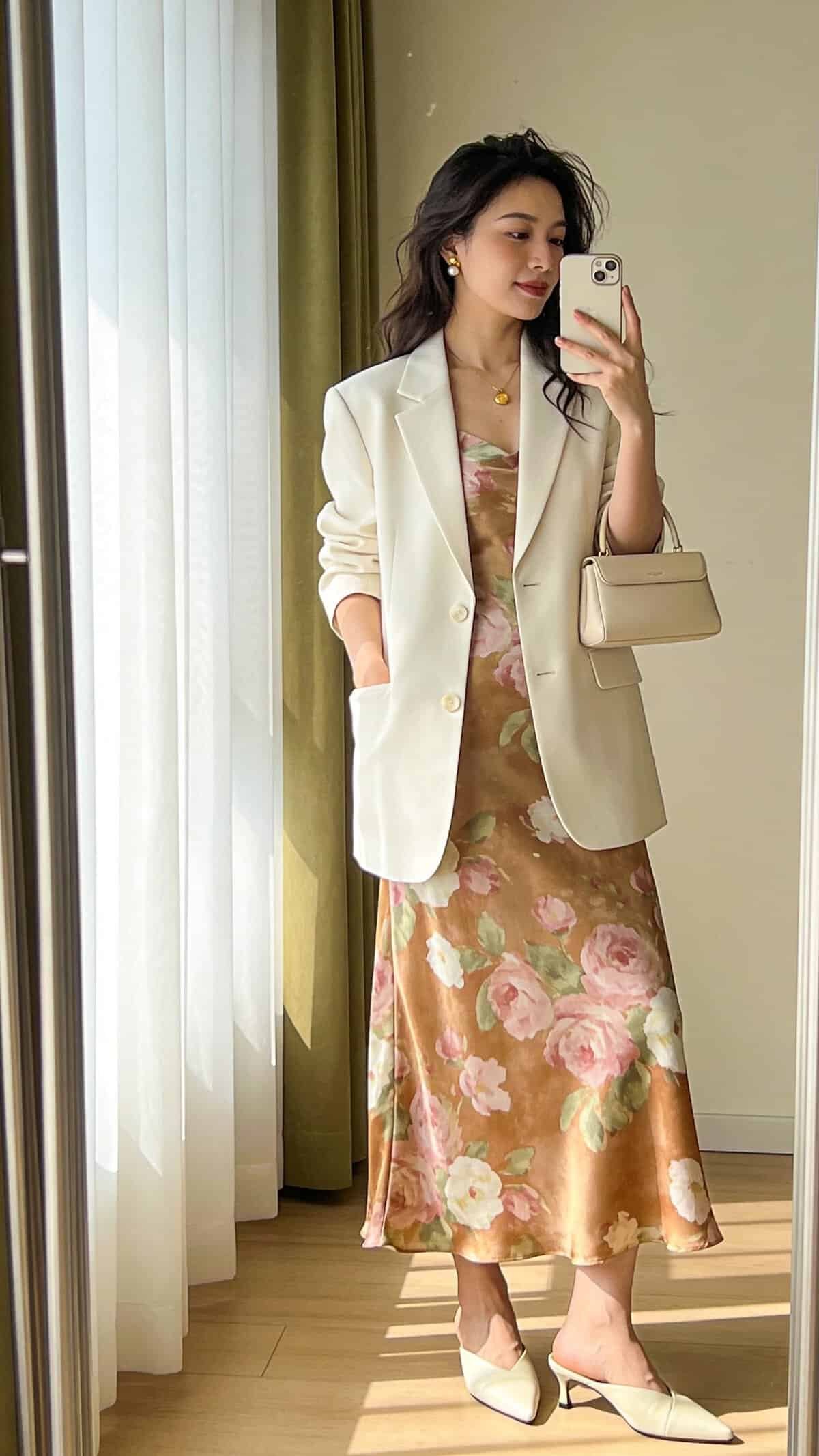 woman taking a selfie wearing white blazer over brown floral print midi slip dress