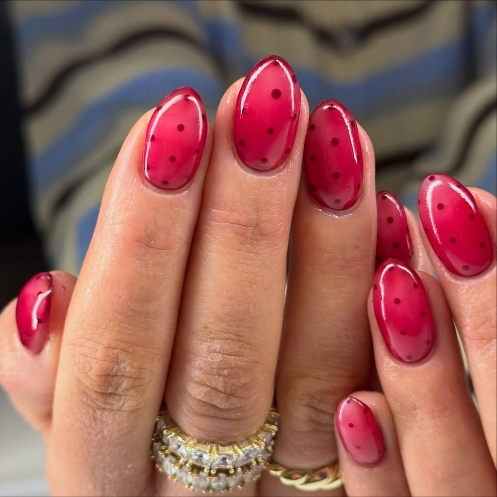 translucent red jelly almond fall nails decorated with small dark red polka dots