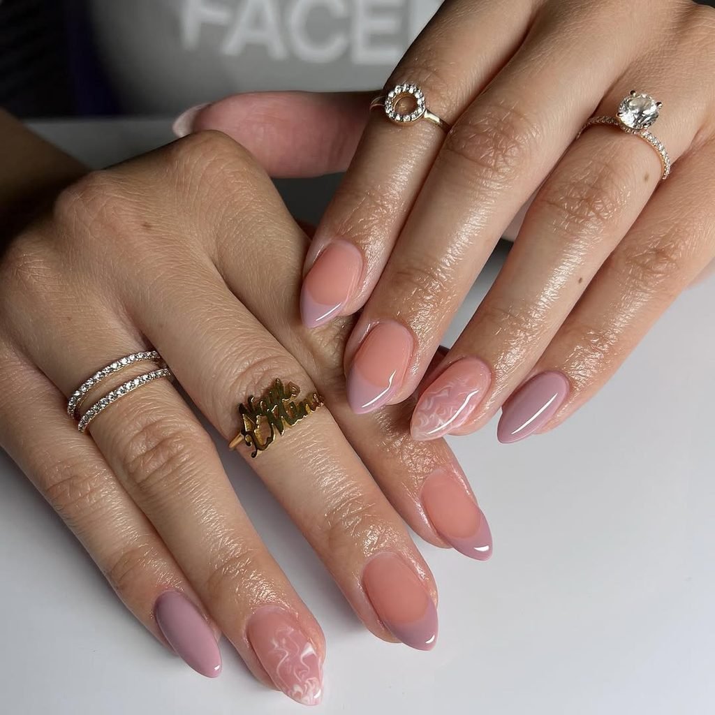 almond shaped manicured hands featuring pink and mauve french tips with marble art