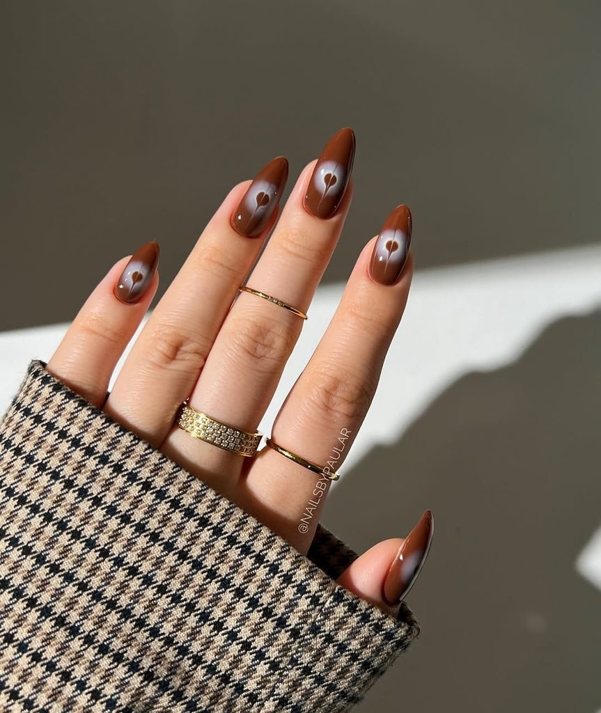 glossy brown almond fall nails featuring a white blurry aura heart in the center