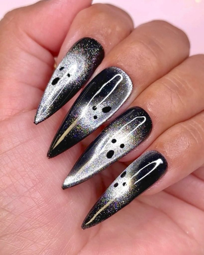 silver and black magnetic stiletto nails painted with simple black ghost faces
