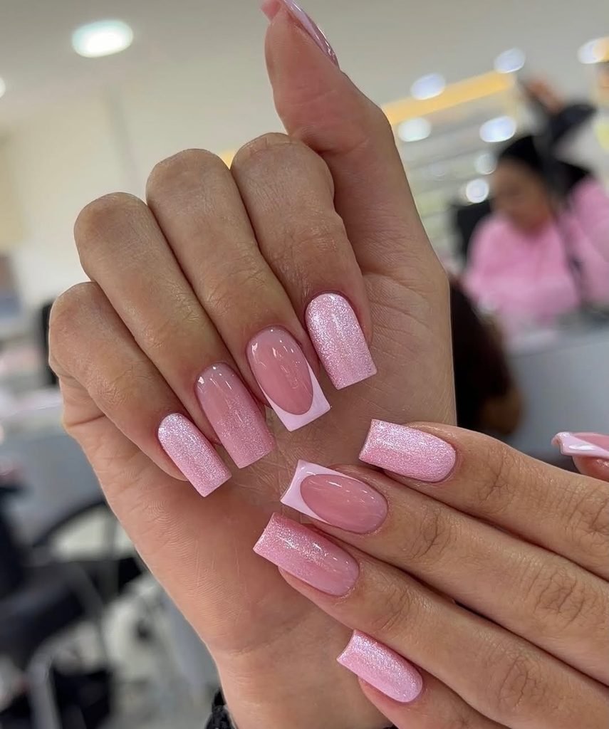 light pink square nails with mixed glitter accents and french tips on hands