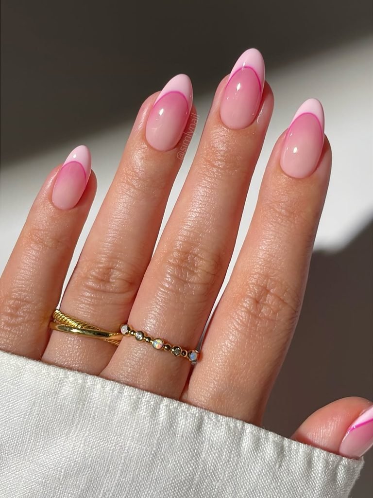 pink french tip almond nails with hot pink outline design and gold rings