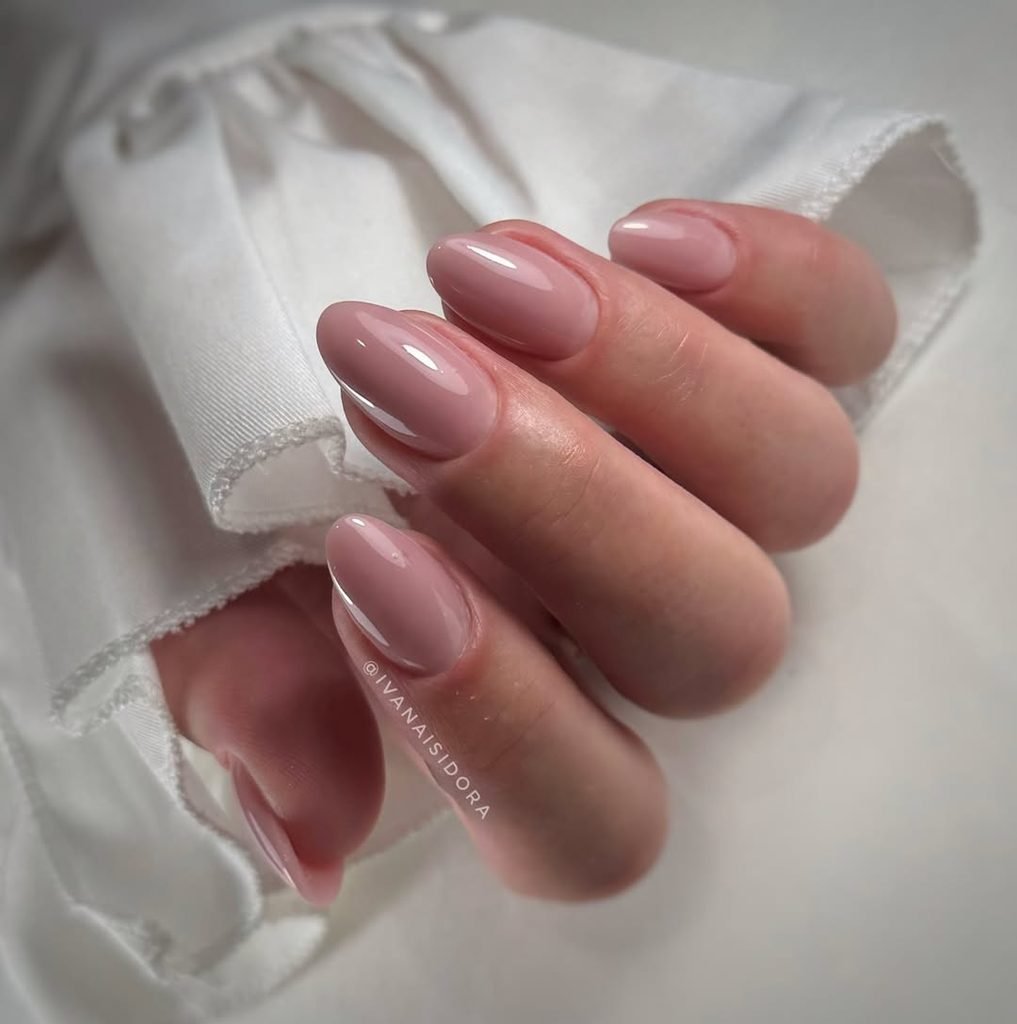 glossy dusty pink oval nails with a white ruffled sleeve background