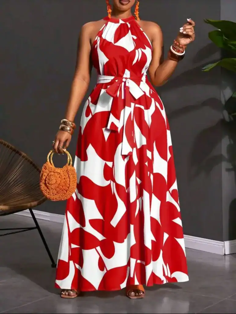 woman wearing a red and white abstract print halter neck maxi dress with a sash