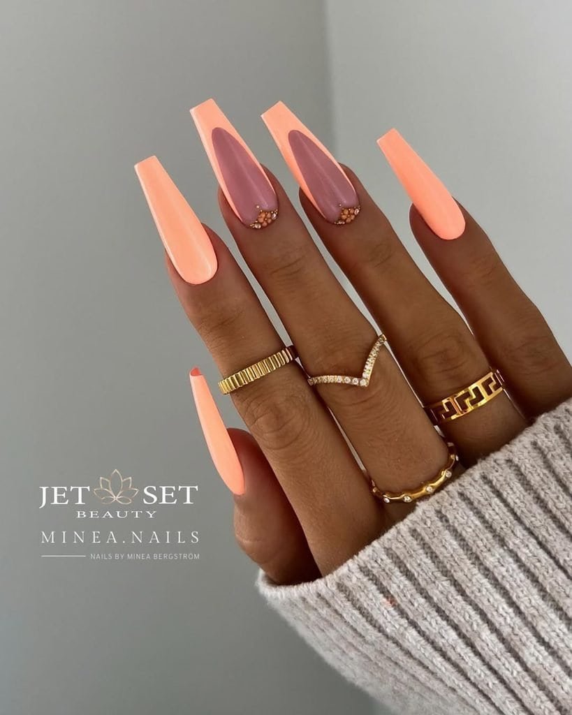 long pastel orange coffin manicure with wide french tips and delicate rhinestone accents